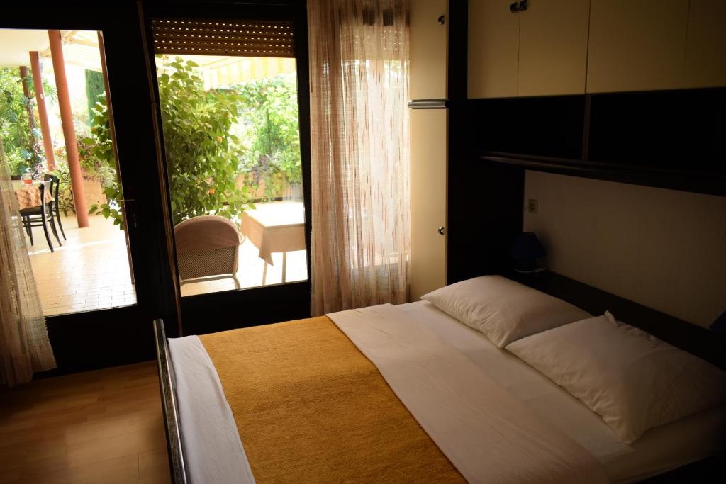 a bedroom with a bed with a view of a patio at Rooms Vila Mautner in Vodice
