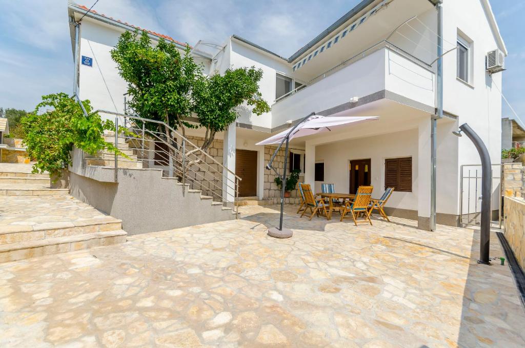 a house with a patio with a table and an umbrella at House Ivana in Vinišće
