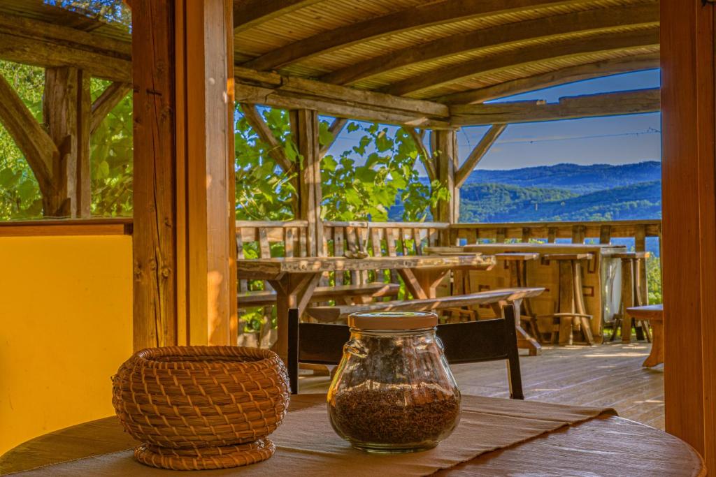Grey green and fun 4 YOU - 2 Cottages في Drganja Sela: طاولة عليها مزهرية زجاجية على الشرفة