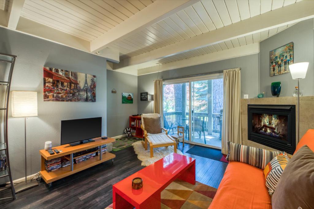 a living room with an orange couch and a fireplace at The Cozy Downtime Condo in Incline Village