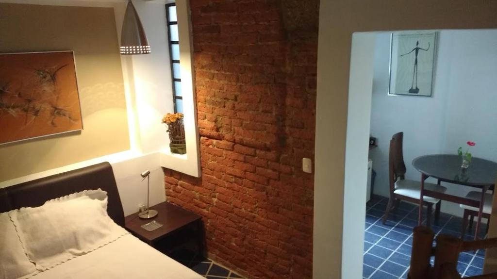 a bedroom with a bed and a brick wall at Junior SUITE M&J in Caracas