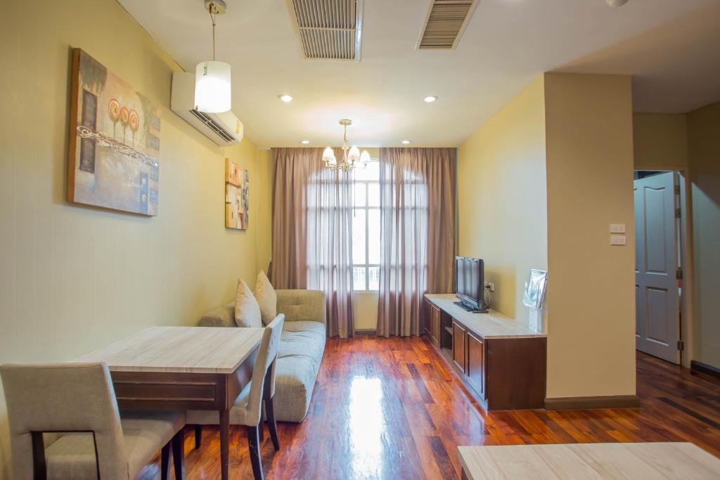 Greenview Ekkamai10 Suite في بانكوك: غرفة معيشة مع أريكة وطاولة