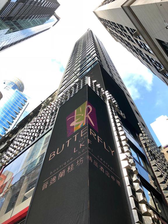 Un palazzo alto e nero con un cartello sopra. di Butterfly on LKF, Central a Hong Kong