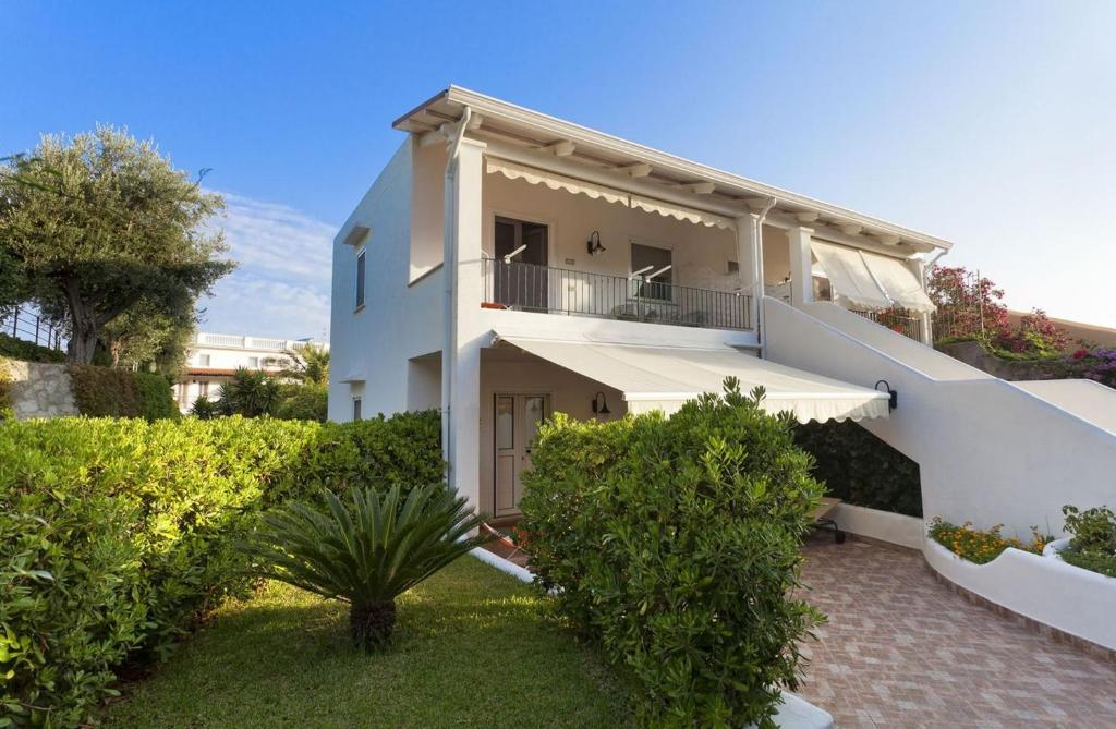 a white building with a balcony and some bushes at Casa Vacanze Parco Del Generale in Ischia