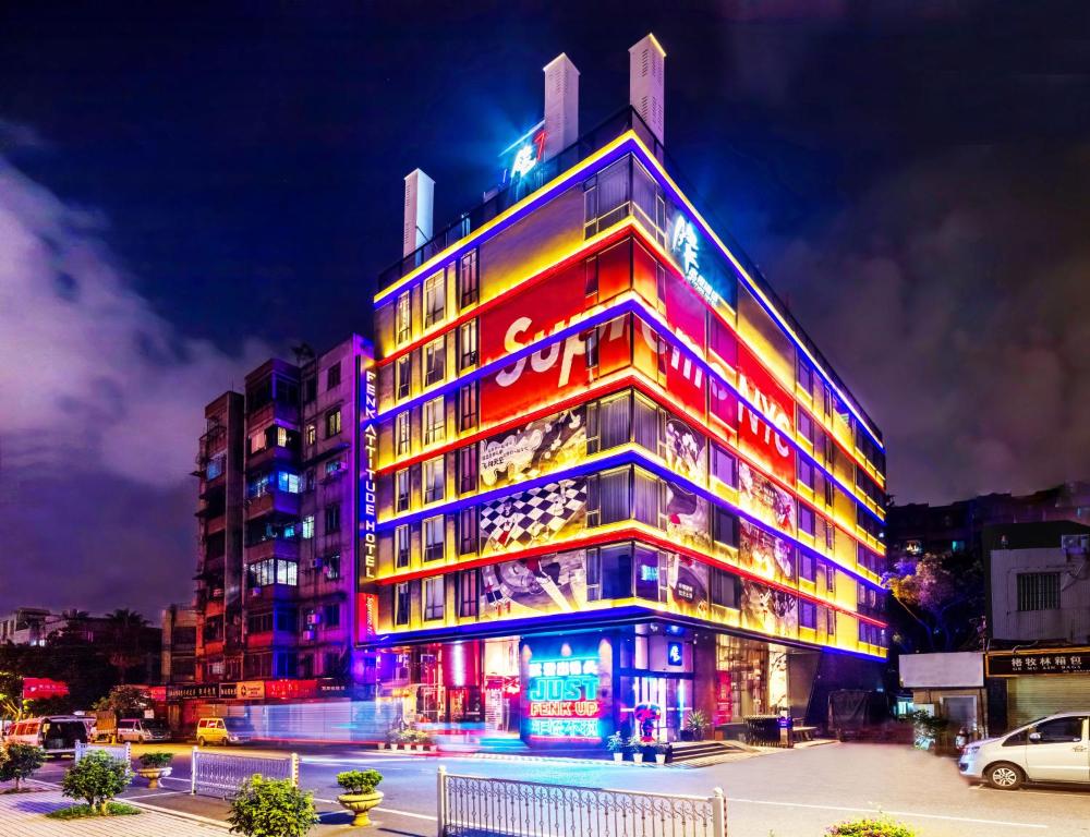 a building with colorful lights on the side of it at Fenk Attitude Hotel Guangzhou Railway Station in Guangzhou