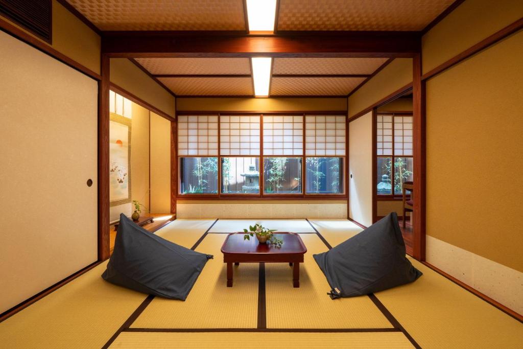an empty room with a table and two pillows at UTAIMACHI in Kanazawa