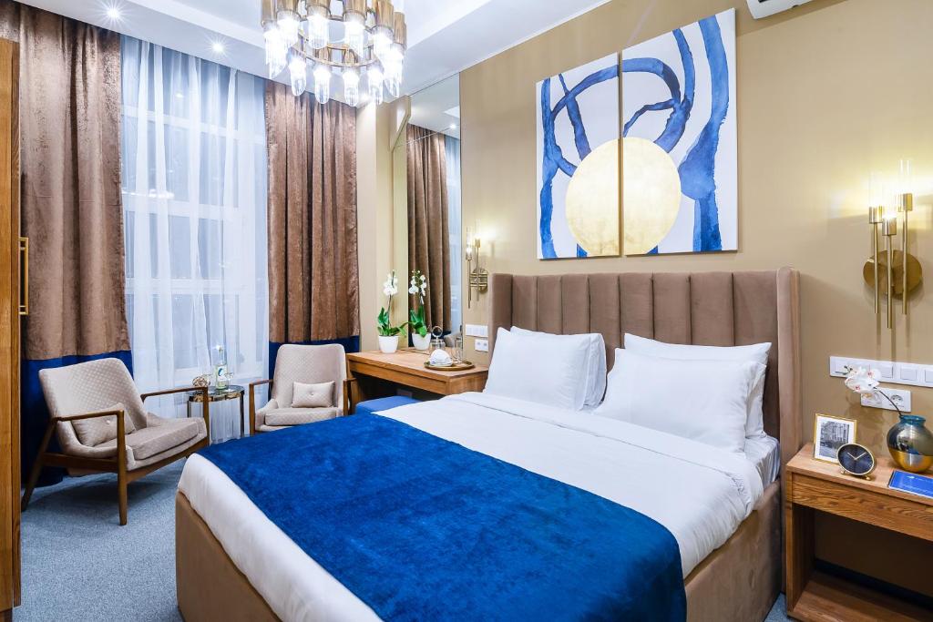 a bedroom with a large bed with a blue blanket at Lido Central hotel in Vladivostok