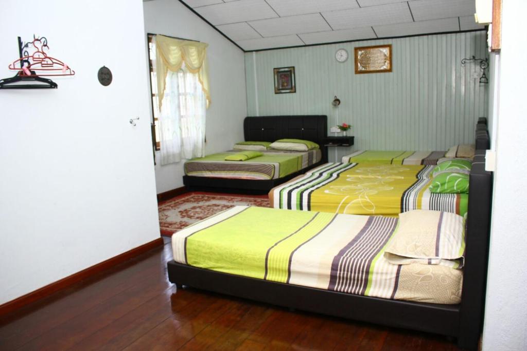 سرير أو أسرّة في غرفة في Homestay Syams