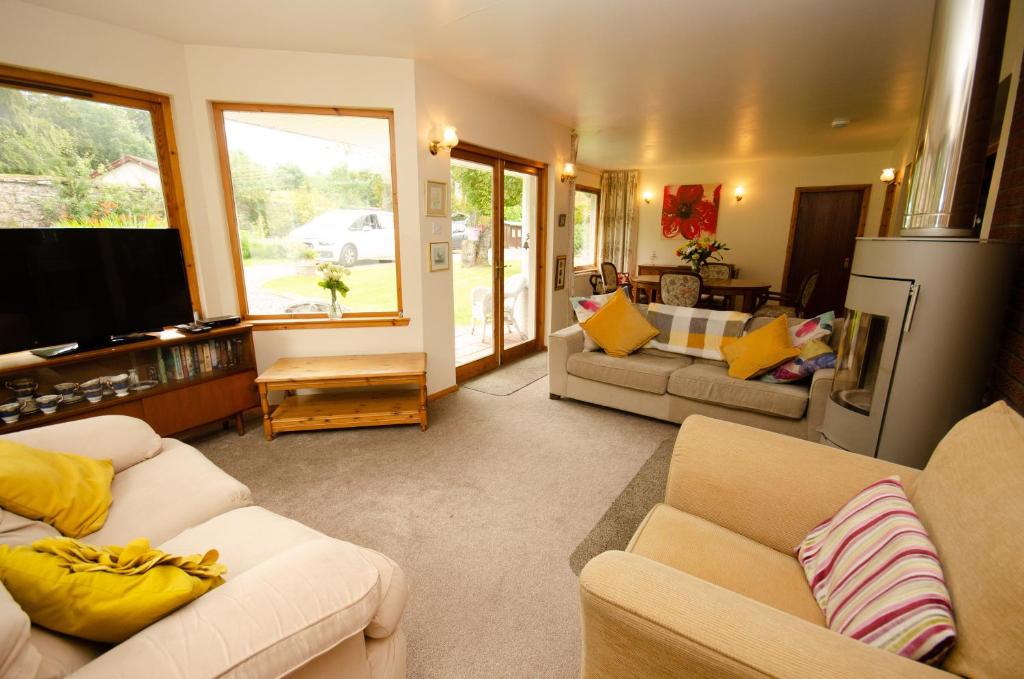 a living room with two couches and a tv at Home Comforts in Peaceful 2 Acres in Inverness