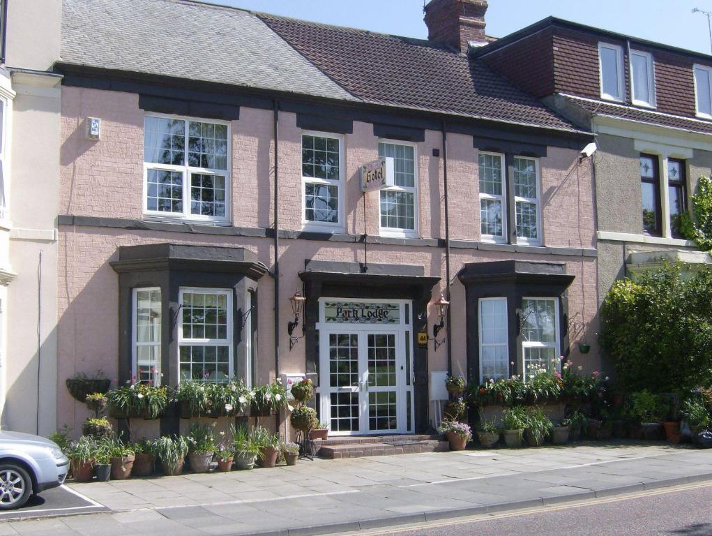 um edifício cor-de-rosa com flores à frente em Park Lodge Guest House em Whitley Bay