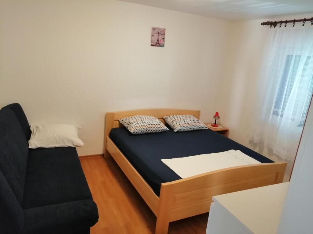 ein kleines Schlafzimmer mit einem Bett und einem Sofa in der Unterkunft Apartment with sea view terrace in Betina
