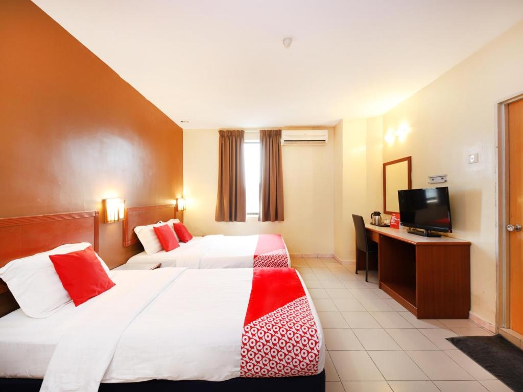 a hotel room with two beds and a television at Super OYO 447 Comfort Hotel Meru in Klang