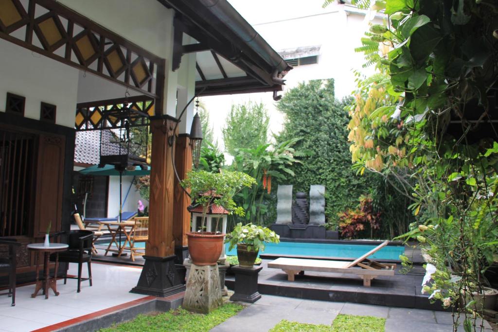 un patio con piscina, mesa y sillas en Griya Yunika, en Yogyakarta