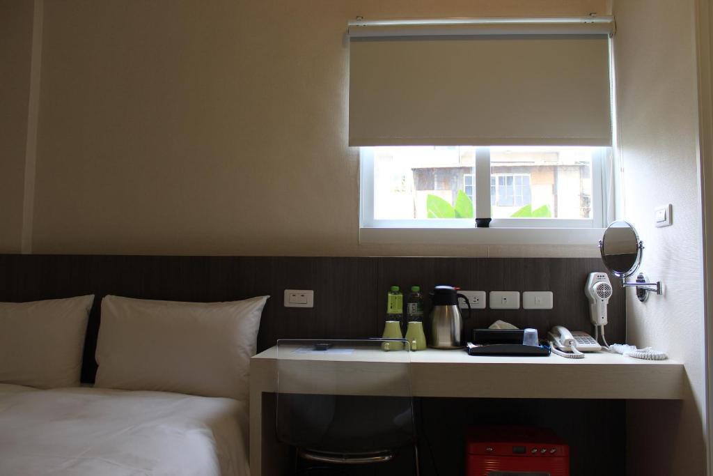 a hotel room with a bed and a window at Sunnyside Hotel in Kaohsiung