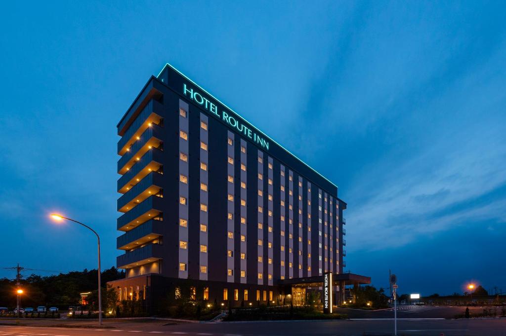 um edifício do hotel iluminado com um sinal em Hotel Route-Inn Kanuma Inter em Kanuma