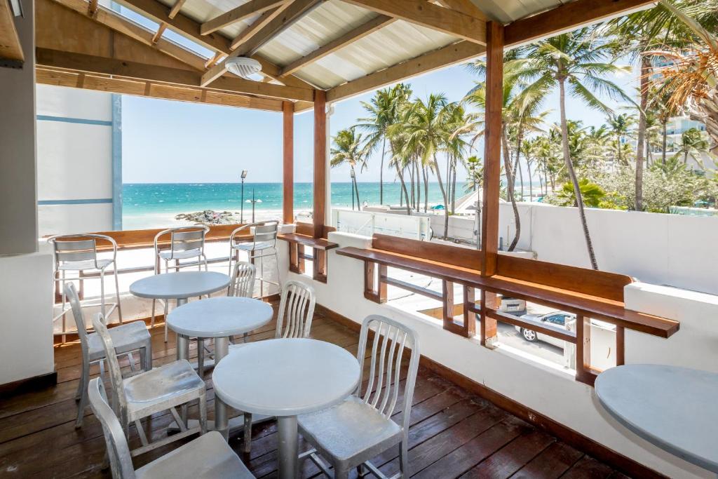 een restaurant met tafels en stoelen en het strand bij Sandy Beach Hotel in San Juan