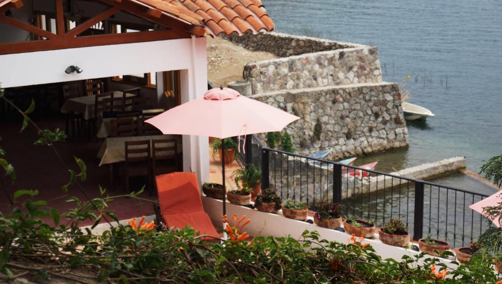 un parasol rose assis sur le balcon d'un bâtiment dans l'établissement Atitlan Villas, à San Antonio Palopó