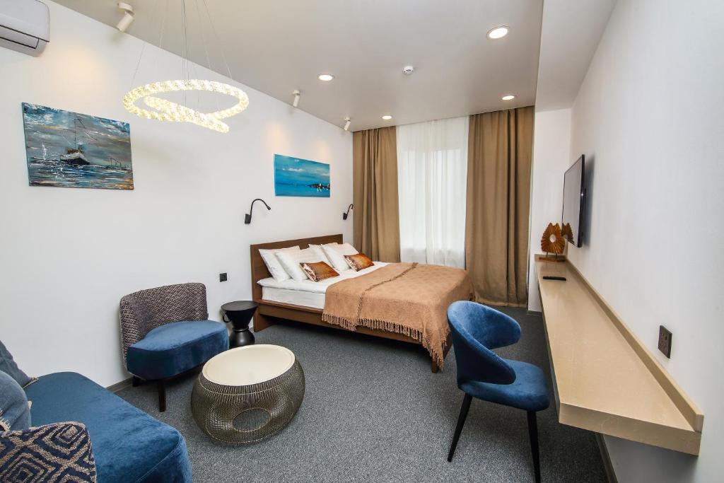 um quarto com uma cama, um sofá e uma televisão em SV Hotel em Vladivostok