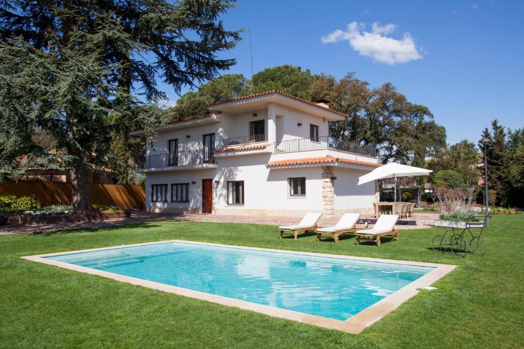 eine Villa mit einem Pool vor einem Haus in der Unterkunft Can Cedre in Lliçà d'Amunt