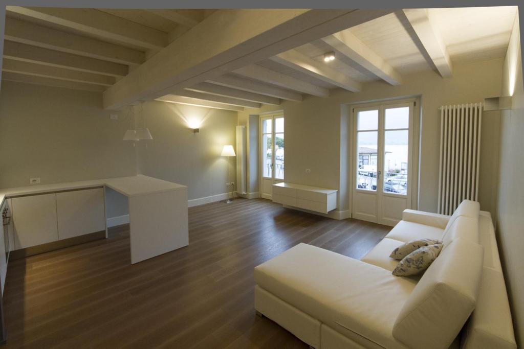 salon z białą kanapą i stołem w obiekcie La Casa Del Porto w mieście Lovere