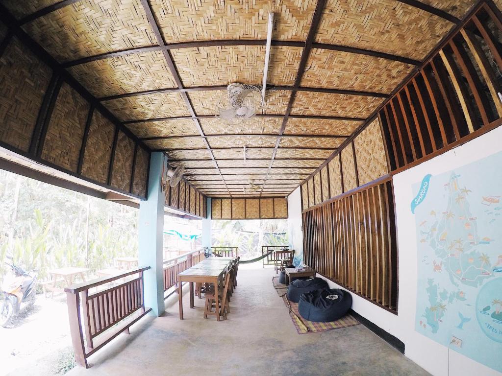 a room with tables and chairs in a building at Tres Islas Hostel in General Luna