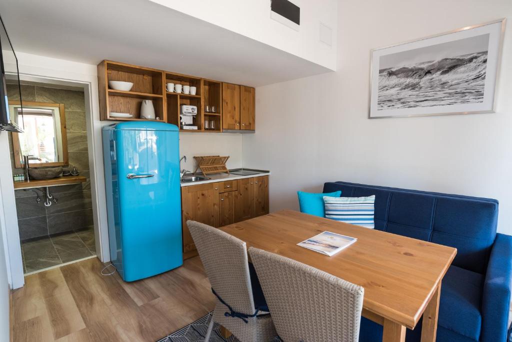 a kitchen with a blue refrigerator and a wooden table at Camping Gradina in Sozopol