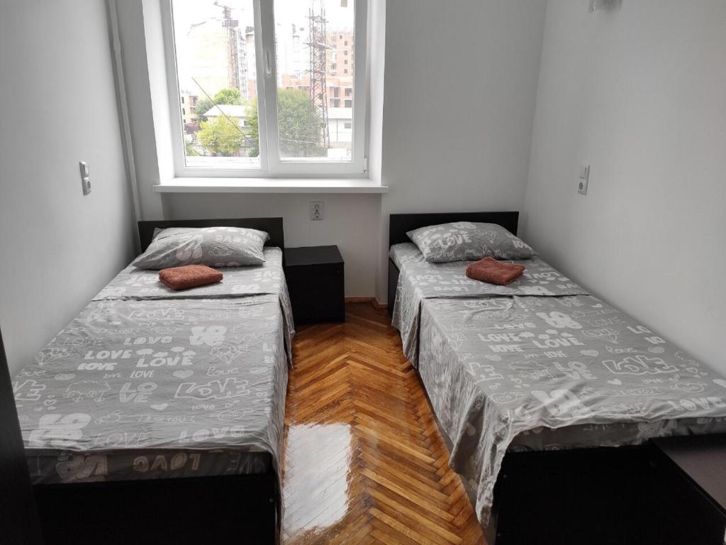 dwa łóżka w pokoju z oknem w obiekcie Дешеві кімнати біля парку w Iwano-Frankiwsku