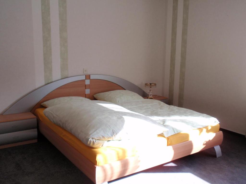 a bed with a wooden headboard in a bedroom at Ferienwohnung Carmen in 36396 Steinau-Ulmbach in Steinau an der Straße