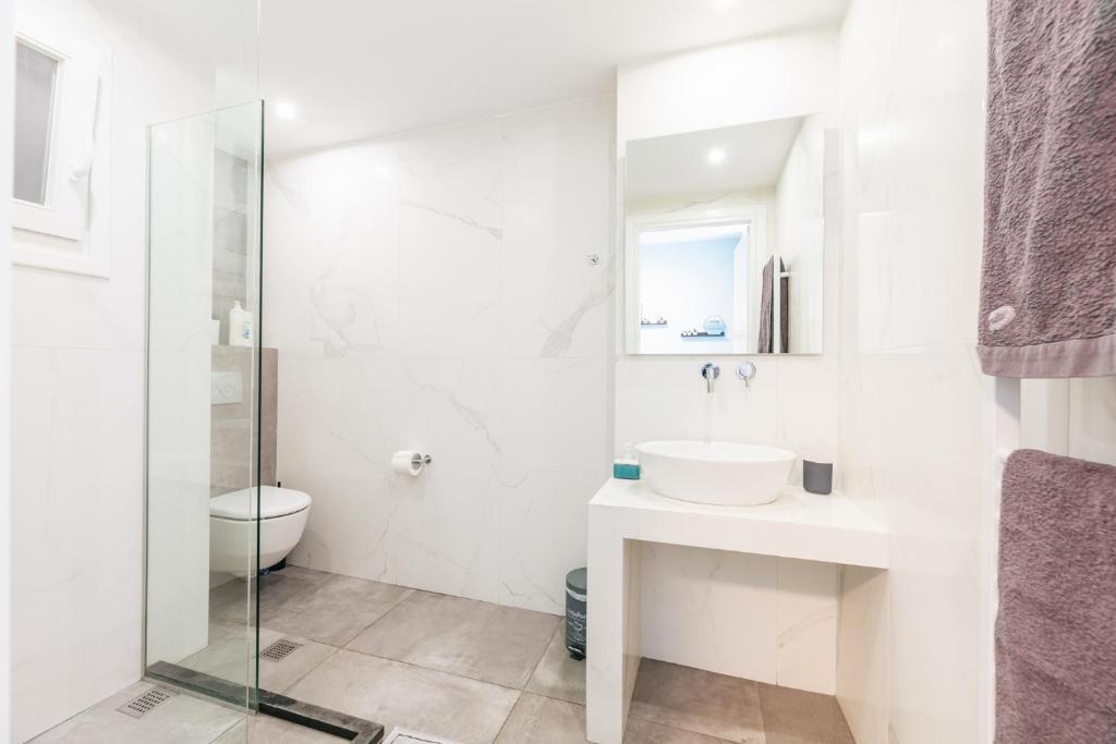 biała łazienka z umywalką i toaletą w obiekcie Modern White Tower Apartment w Salonikach
