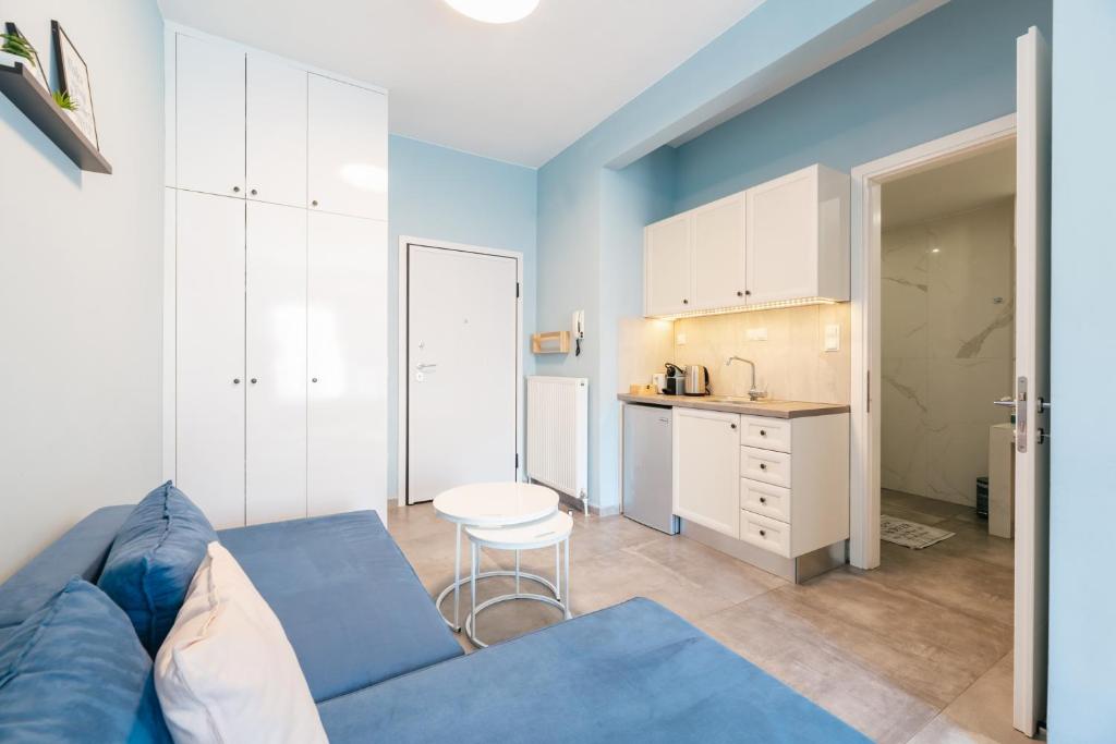salon z niebieską kanapą i kuchnią w obiekcie Modern White Tower Apartment w Salonikach