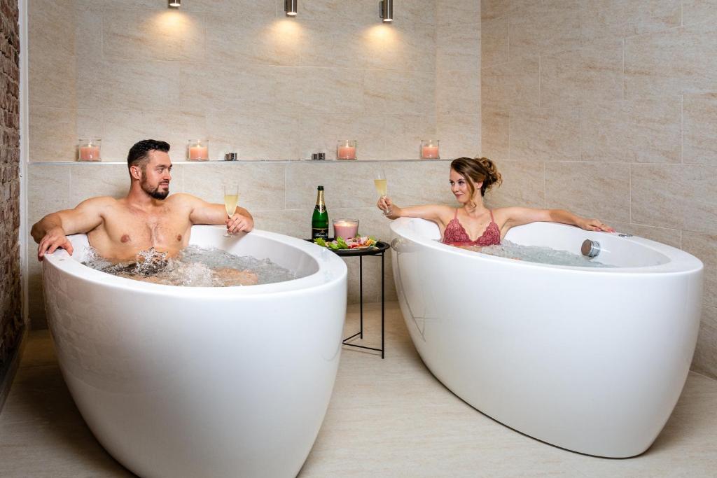 a man and woman in tubs in a bathroom at Dvůr Stráň in Karlovy Vary