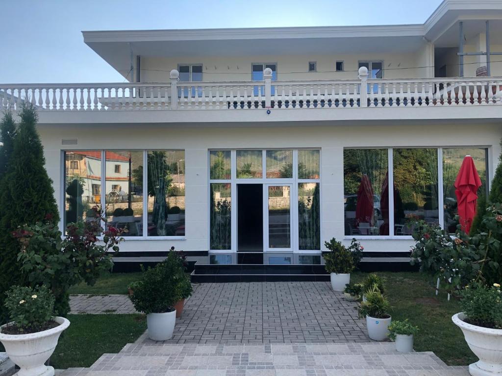 a large white house with a balcony on top of it at Hotel Taverna Zisi in Ersekë