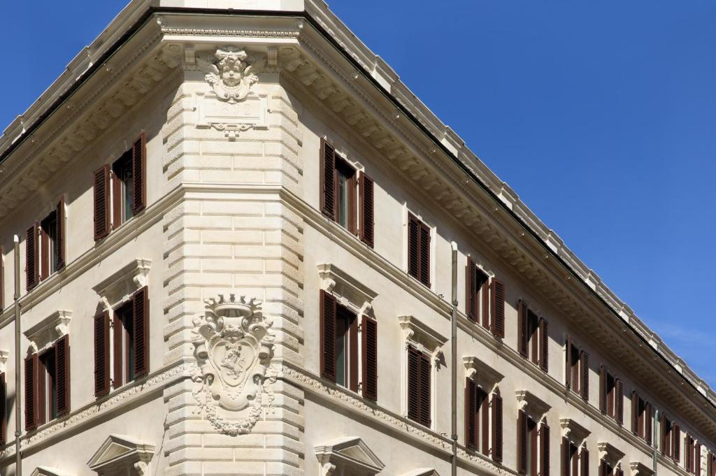 a building with a clock tower on top of it at Rocco Forte House Piazza Di Spagna, Rome in Rome