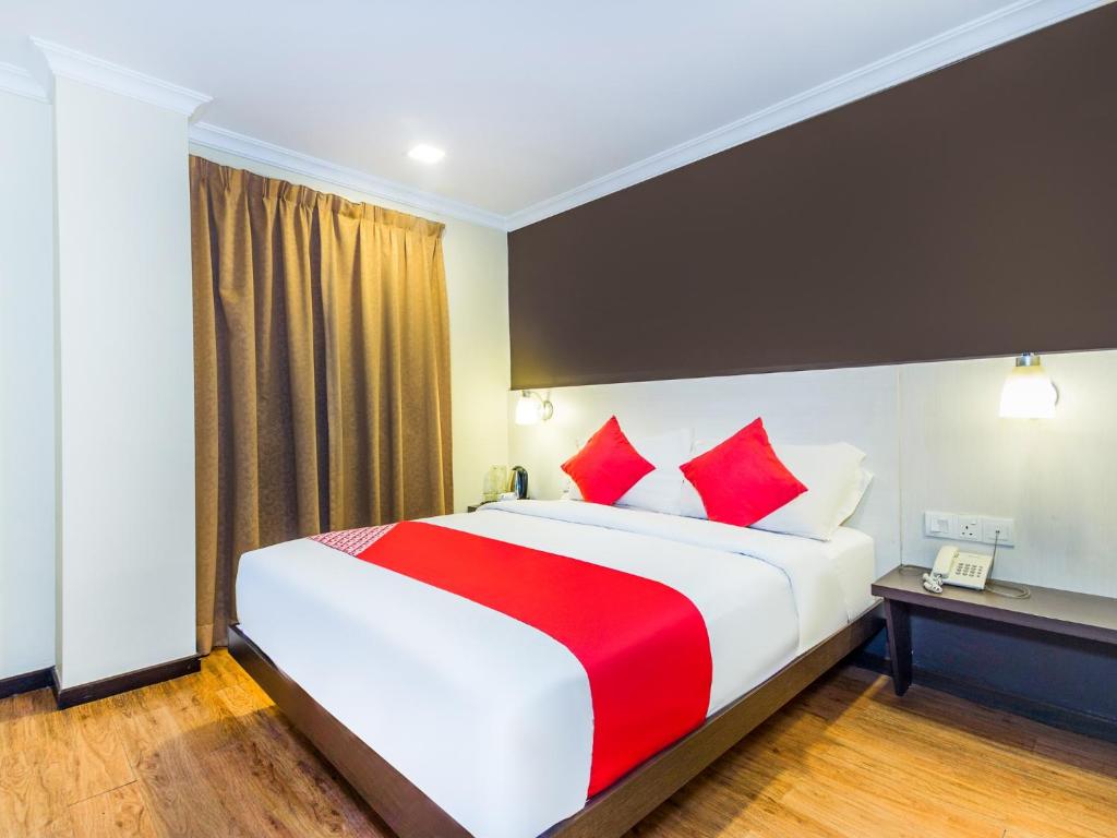 ein Hotelzimmer mit einem großen Bett mit roten Kissen in der Unterkunft OYO 431 Hotel De Grand Orchard in Kuala Lumpur