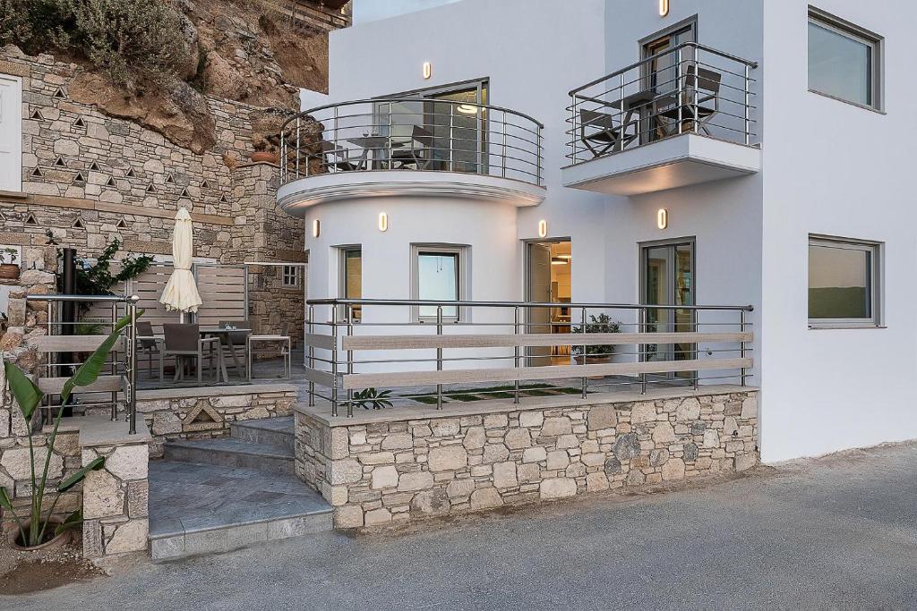 a house with a balcony and a stone wall at Magnolia Luxury Apartments in Falasarna