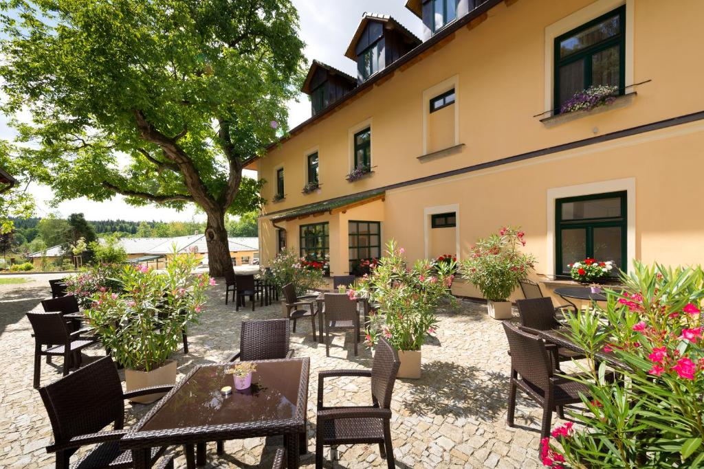 a patio with tables and chairs in front of a building at Resort Johanka in Kamenice nad Lipou