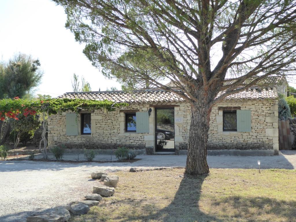 ein Steinhaus mit einem Baum davor in der Unterkunft Mas de l'Amarée in Gordes