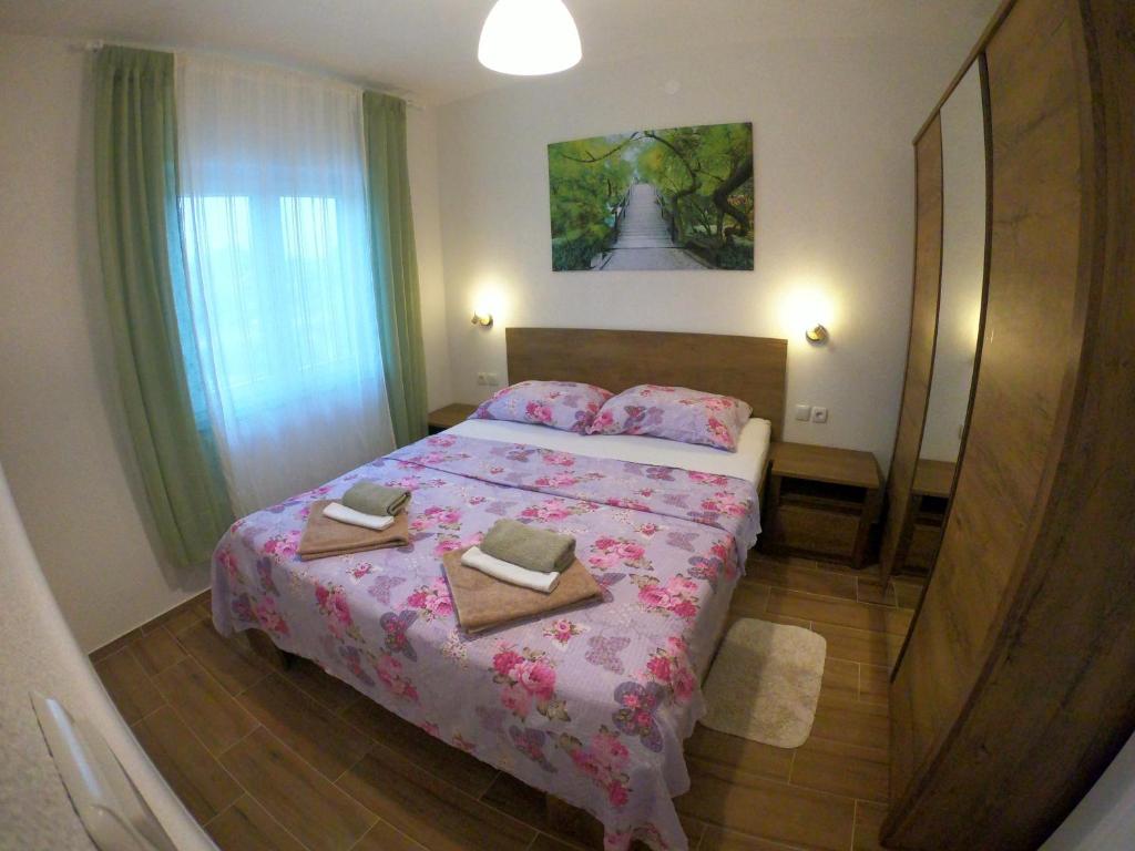 a bedroom with a bed with two towels on it at Apartmani Zekic in Lopar