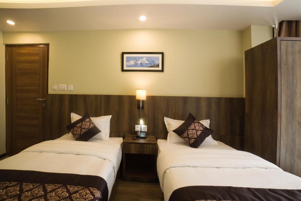 Postel nebo postele na pokoji v ubytování Ganapati Airport Hotel