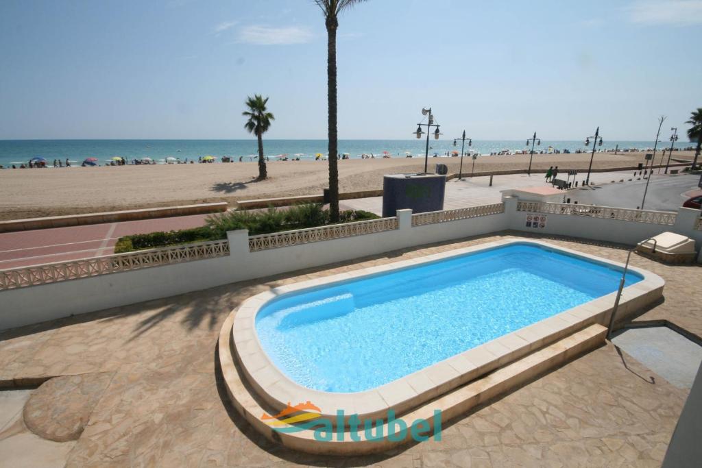 a swimming pool in front of the beach at Apartamentos Barramundi in Peniscola