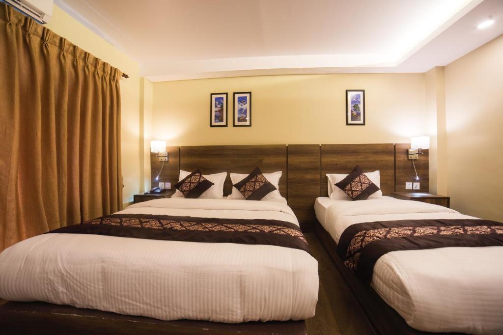 Postel nebo postele na pokoji v ubytování Ganapati Airport Hotel
