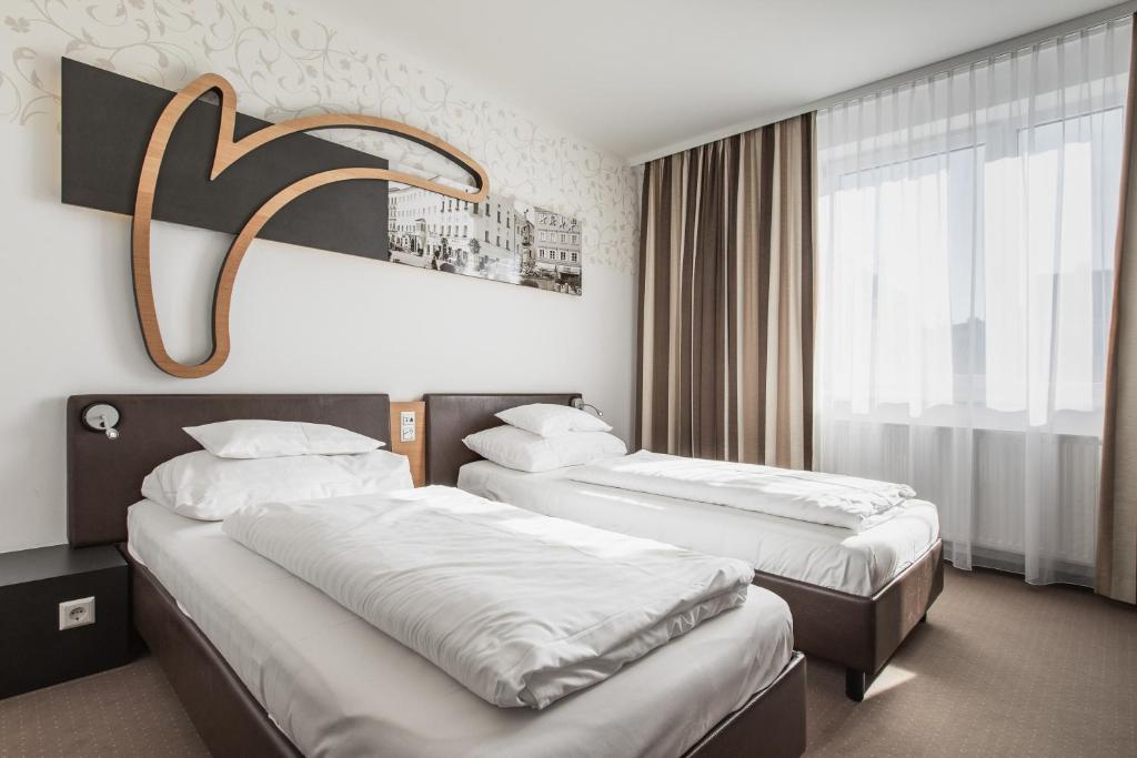 Postel nebo postele na pokoji v ubytování H+ Hotel Ried