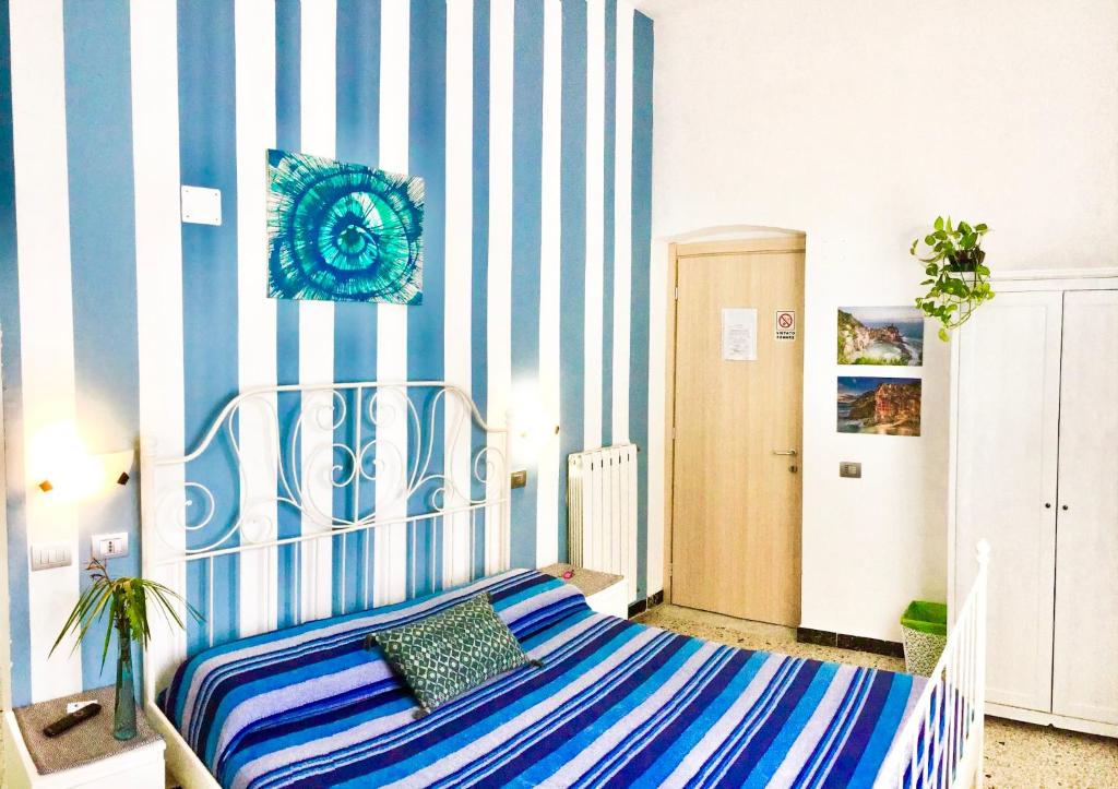 a bedroom with a blue and white striped wall at Levante Blu in La Spezia