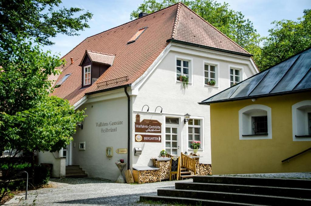 biały budynek z czerwonym dachem w obiekcie Wallfahrts-Gaststätte Heilbrünnl w mieście Roding