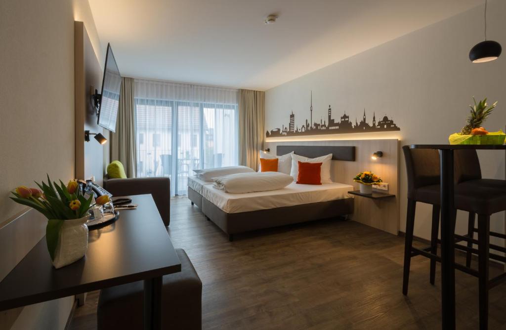 フィルダーシュタットにあるGarni Hotel Schumacherのベッドとテーブルが備わるホテルルームです。