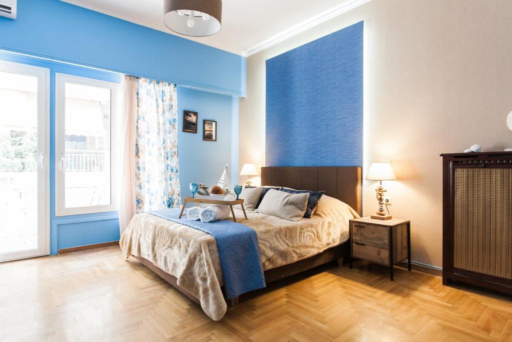 1 dormitorio con cama y pared azul en Cozy, Central, Safe Double rooms in apartment, close to Acropolis en Atenas