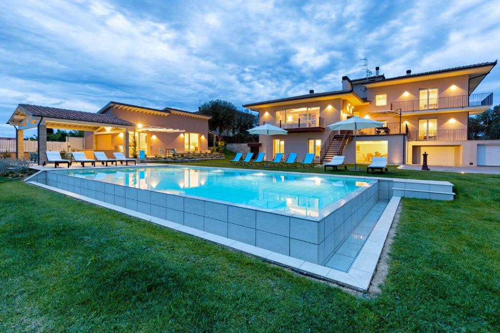 una gran piscina frente a una casa en Villa Spaccasole su Cortona en Foiano della Chiana