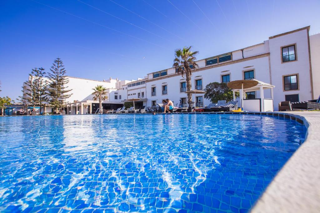 une grande piscine en face d'un bâtiment dans l'établissement Hôtel Des Iles, à Essaouira