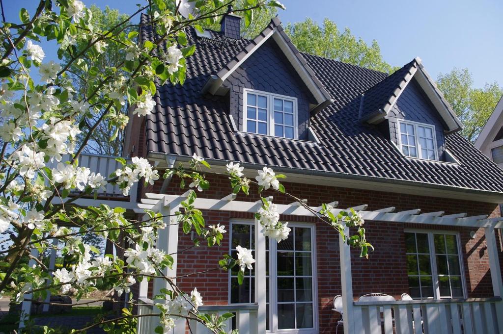 ein Haus mit weißen Blumen davor in der Unterkunft Haus Milena/Jule in Warnemünde