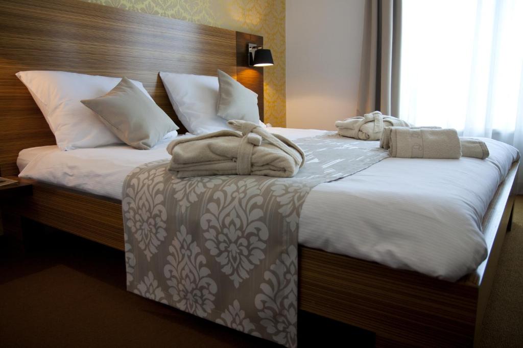 2 Betten in einem Hotelzimmer mit Handtüchern darauf in der Unterkunft Gold Club Hotel & Casino in Ajdovščina